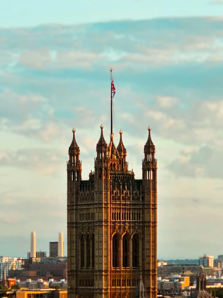 A view of the majestic Victoria Tower at sunset, forming part of the historic Palace of Westminster in London.